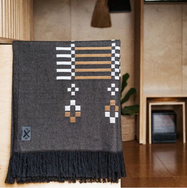 Textile with geometric pattern draped over a surface in a room setting