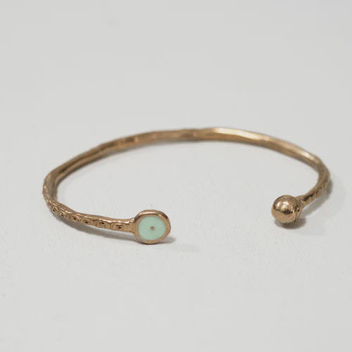 Bronze cuff bracelet handmade in Florence Italy with light blue resin detail on grey background