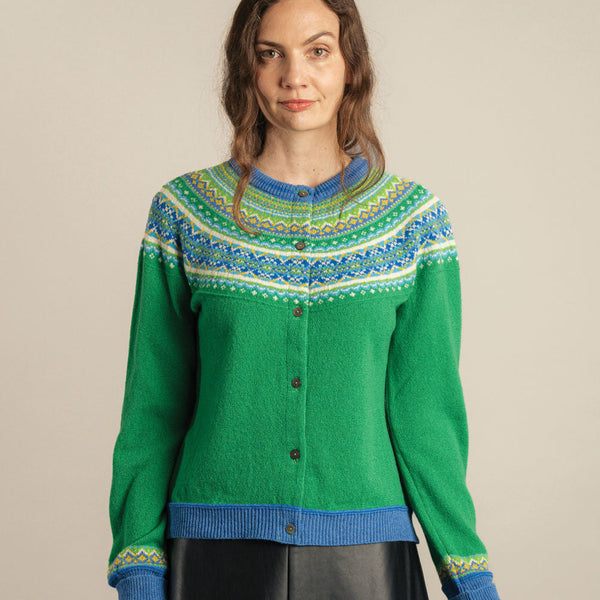Woman wearing a green Eribe cardigan with blue and green pattern on a beige background