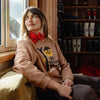 Woman sitting in a room with a window and shelves filled with shoes