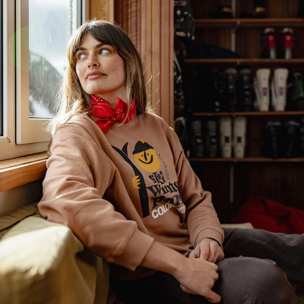 Woman sitting in a room with a window and shelves filled with shoes