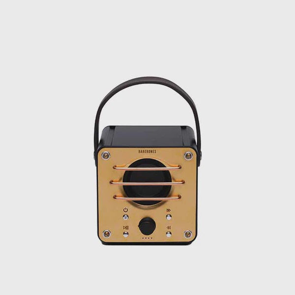 Portable radio-style speaker with a black top and gold body on a light gray background