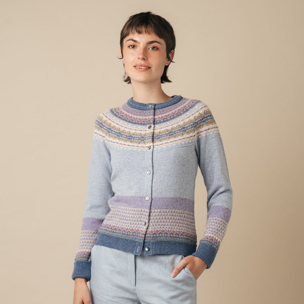 Woman wearing an Eribe cardigan against a beige background