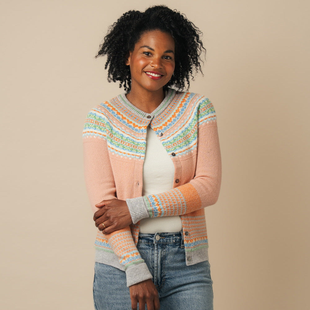 Woman wearing an Eribe cardigan with a beige background