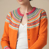 Person wearing a colorful Eribe cardigan with a patterned design on a beige background