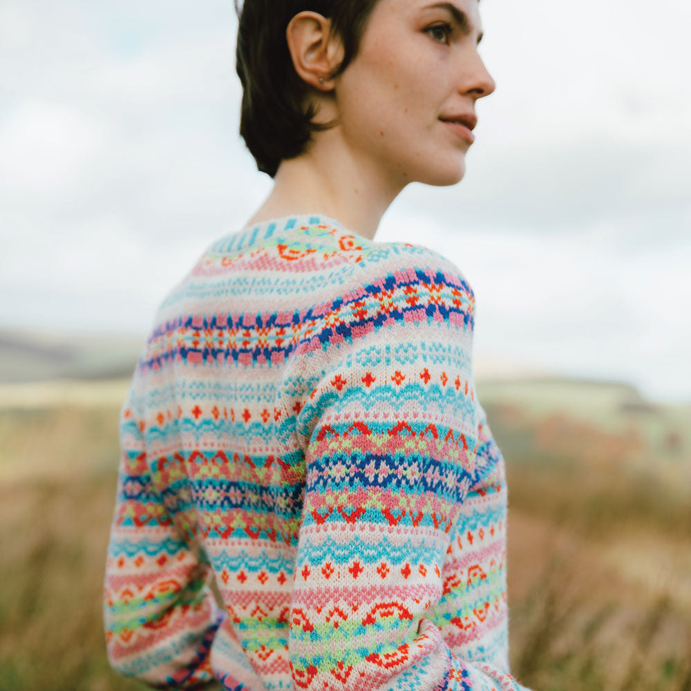 Person wearing a colorful patterned Eribe cardigan in a natural setting