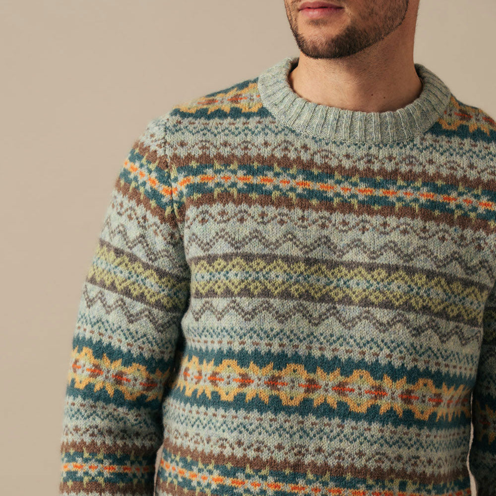 Man wearing a patterned Eribe sweater with a neutral background
