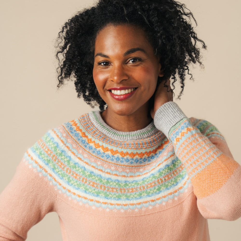 Woman wearing a Eribe sweater with a neutral background