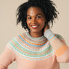 Woman wearing a Eribe sweater with a neutral background
