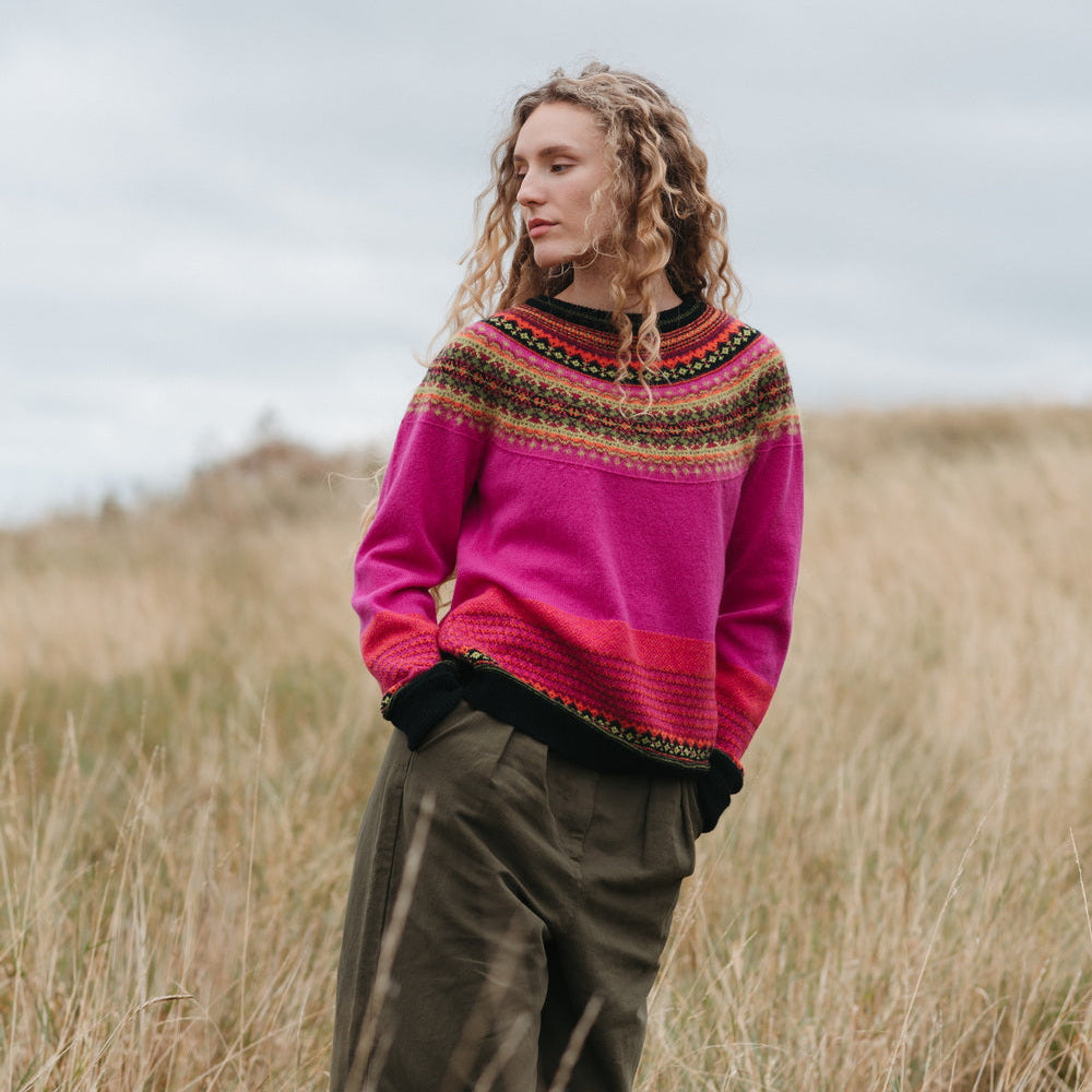 Person wearing a Eribe sweater standing in a grassy field