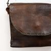 Brown leather bag with visible stitching on a white background