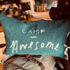 Teal pillow with 'Camp Awesome' text held by a person in an outdoor setting Pony Rider