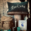 Camp-themed pillow with 'Camp Awesome' text, backpack, thermos, and other items on a wooden stand.