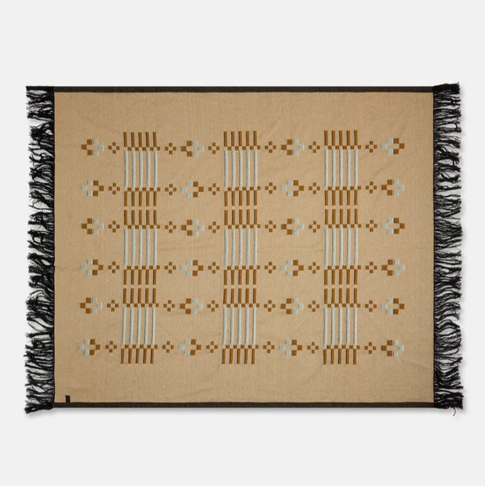 Beige woven blanket with black fringe on a white background