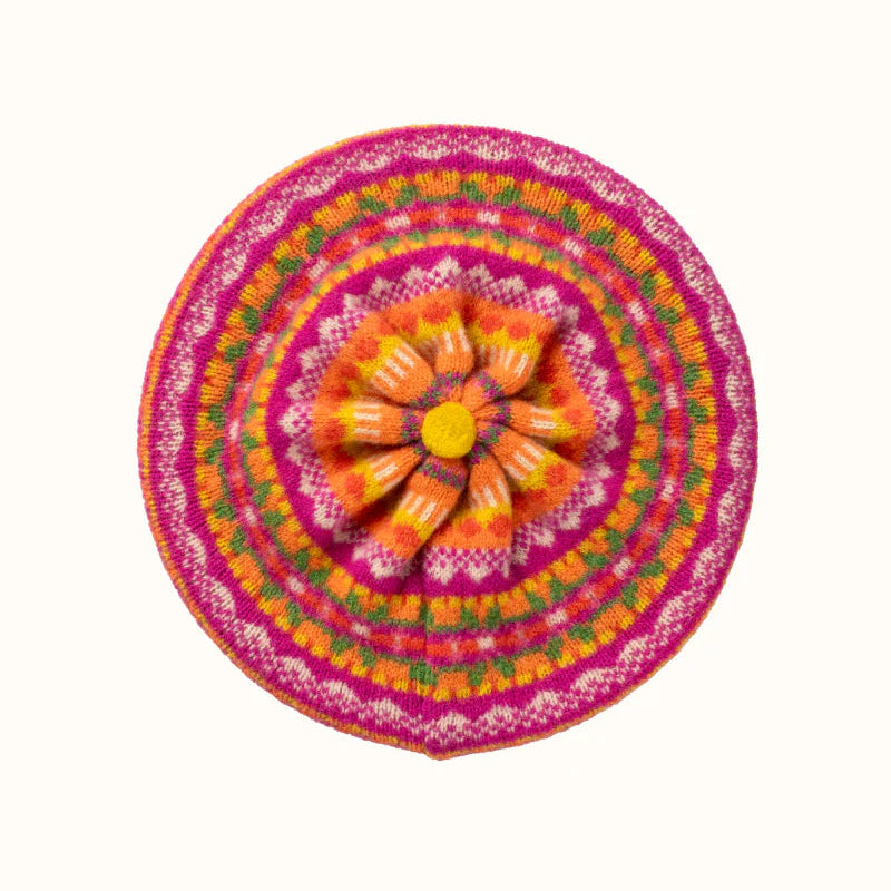 Colorful round woollen beret with a pink border on a white background