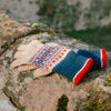 Colorful knitted glove on a stone surface with a natural background