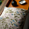 Floral-patterned pillow on a wooden surface with decorative items.
