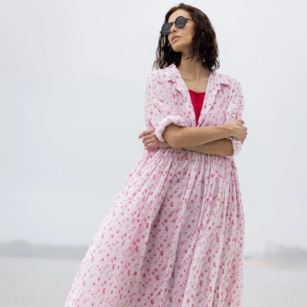 Woman wearing a pink floral dress with a white background