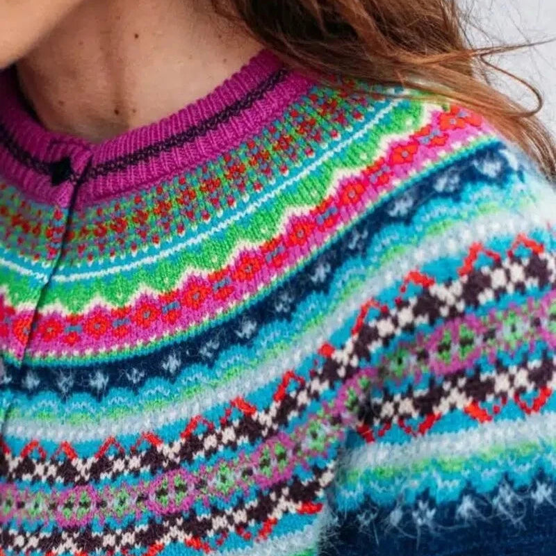 Close-up of a colorful patterned Eribe sweater with a blue background