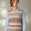 Woman wearing a colorful patterned Eribe vest over a light blue shirt against a neutral background